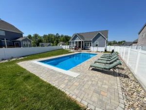 Small rectangular pool with paver patio surrounding.