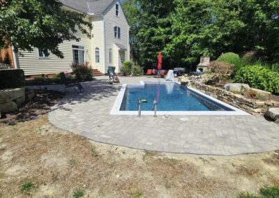Before photo of an old paver patio around pool.