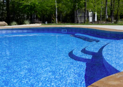 Unique shaped freeform swimming pool with steps going into pool.