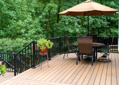 tan deck with table, chairs and umbrella.