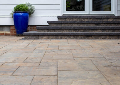 Stone steps from paver patio up to house.