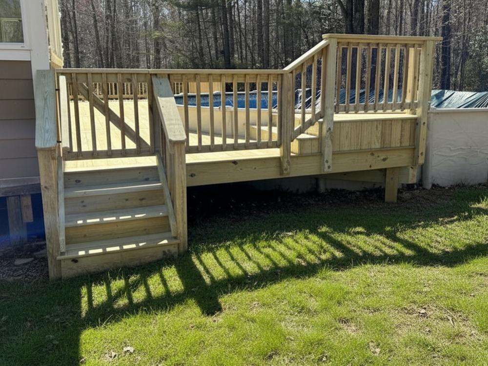 Light-colored wooden deck featuring a short flight of stairs, a latching gate, and vertical railings next to a pool.